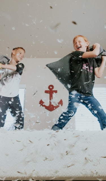 children-playing-with-pillows-in-the-bedroom